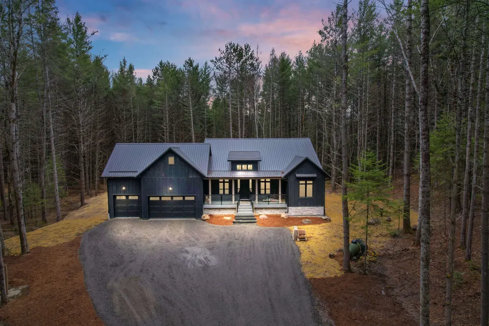 Dwight Beach Road custom home at dusk, board and batten under a steel roof